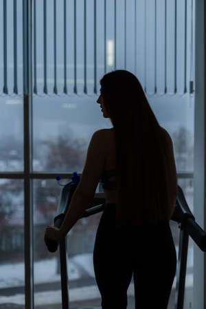 Attractive young sports woman is working out in gym. Doing cardio training on curve treadmill....