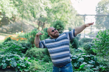 .Young man with round glasses and overweight in the park.の写真素材