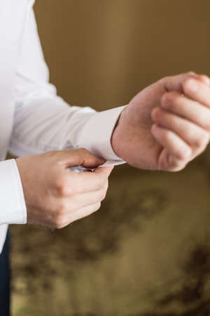 Sexy man buttons cuff-link on French cuffs sleeves luxury white shirt.の写真素材