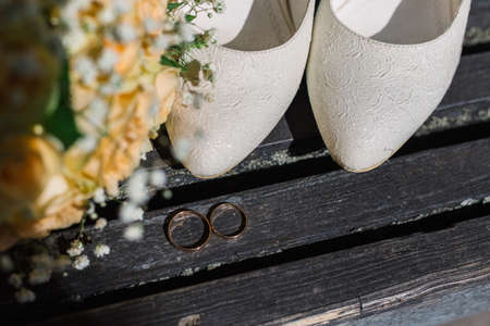 Wedding bouquet rings and shoes of the bride in the sun.の写真素材
