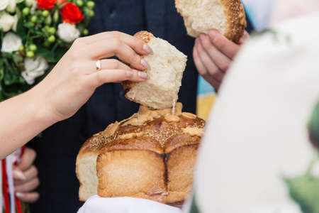 The bride and groom break the wedding loaf.
