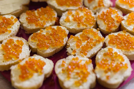 Delicious toasts with red caviar on the holiday table.