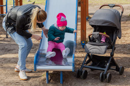 Happy mom and daughter play on the playground.の写真素材