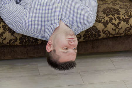 Young man upside down on a couch.の写真素材
