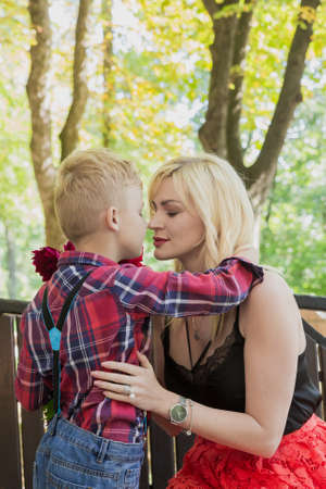Little beautiful boy gives flowers to mom.の写真素材