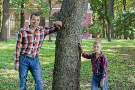 Beautiful dad and son are walking in the park.の写真素材