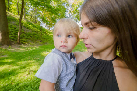 Beautiful mother and little son in green plants.の写真素材