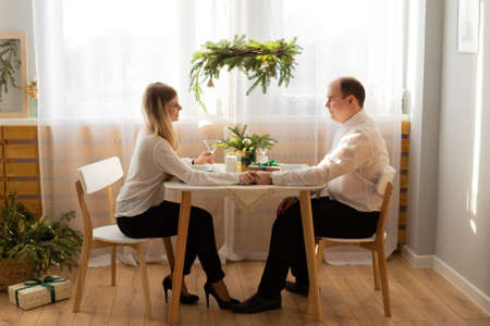 Happy husband and wife at the New Years table.の写真素材