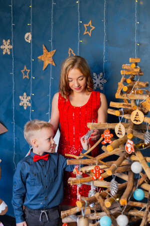 Happy boy with mom in a Christmas tree decor.