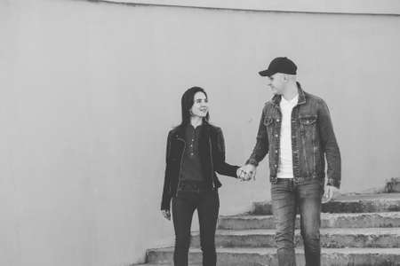 Loving couple walk up the concrete stairs and hold hands.