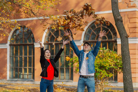 Happy lovers in yellow leaves in the autumn in the park.