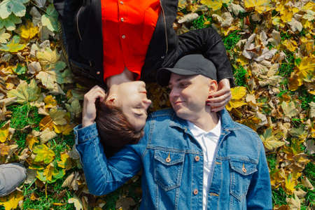 Happy lovers in yellow leaves in the autumn in the park.