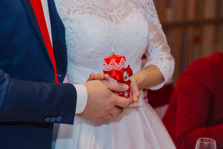 Happy newlyweds hold a candle in their handsの写真素材