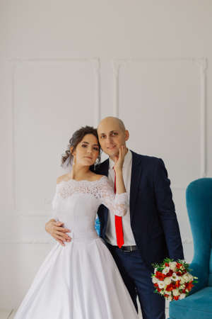 Happy bride and groom in a room hug each other.の写真素材