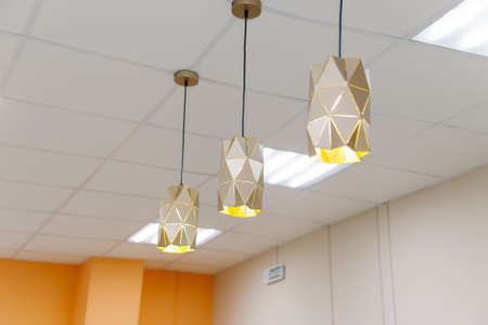 Three beautiful chandeliers on the ceiling in a clothing storeの写真素材