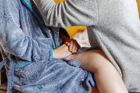 Tender hands of a young girl in a home coat.の写真素材