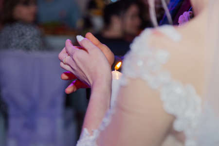 Beautiful newlyweds light a candle at a wedding celebration.の写真素材