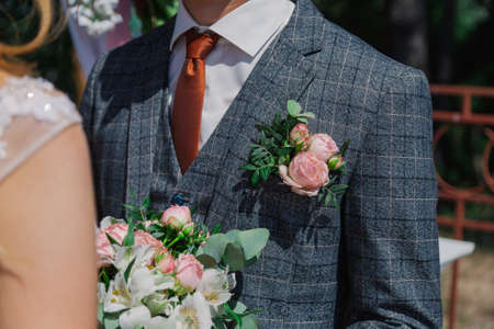 Young and happy bride and groom holding a wedding bouquet in their hands.の写真素材
