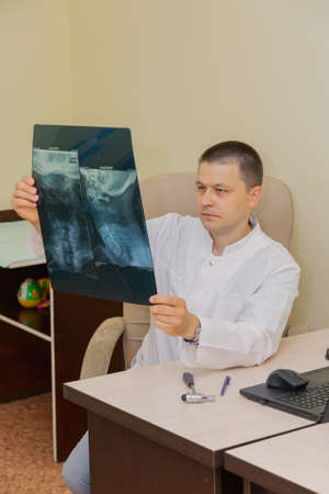 Doctor male neurologist with x-ray picture in his hands.