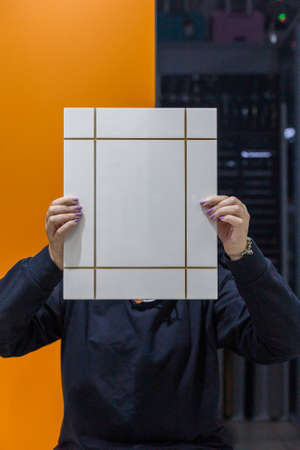 Young woman with kitchen facade sample in hands.の写真素材