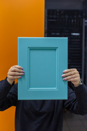 Young woman with kitchen facade sample in hands.の写真素材