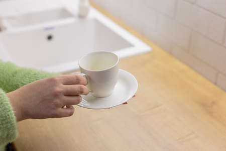 Young woman with a cup in the kitchen. Kitchen furniture.の写真素材