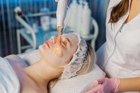 Darsonvalization of the face or rejuvenation of the face with the help of electrotherapy. Photo of...