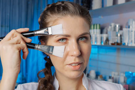Professional beautician with brushes at his face.の写真素材