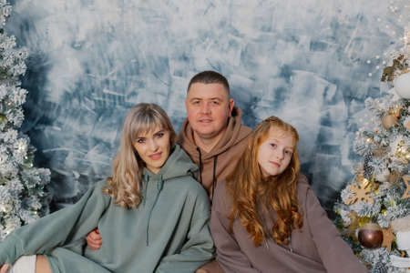 Beautiful and happy family at the New Year tree at a photo shoot.の写真素材
