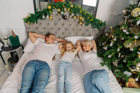 Beautiful young happy family on the new years bed.の写真素材
