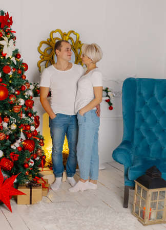 Young beautiful couple by the Christmas tree.の写真素材