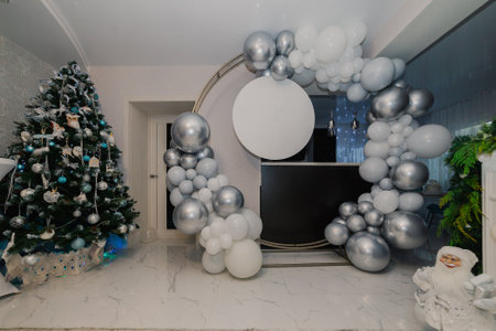 A round photo zone is made of white and silver balloons as well as a place for your inscriptions on a round plate. overall plan. Christmas treeの写真素材