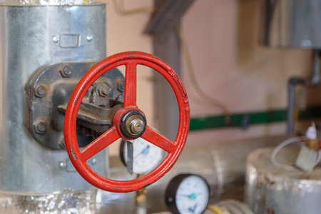 Red big faucet on the pipe in the basementの写真素材