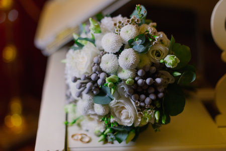 A beautiful wedding bouquet of golden rings of the newlyweds lie on the surface of a white piano. Wedding dayの写真素材