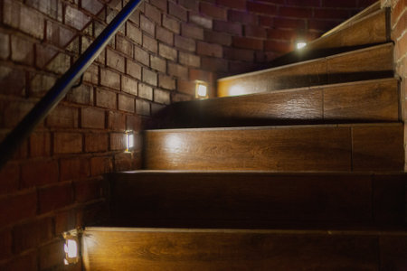 A beautiful wooden staircase with illuminated brick trim goes up