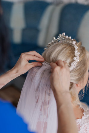 An elderly mother puts on a veil for the bride on her wedding dayの写真素材