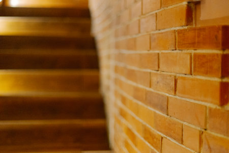 The brick wall in the room specially processed against the background of a wooden staircase with backlightの写真素材