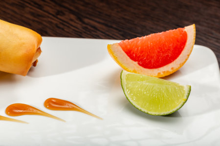 Stuffed food on a white plate with lime and grapefruitの写真素材