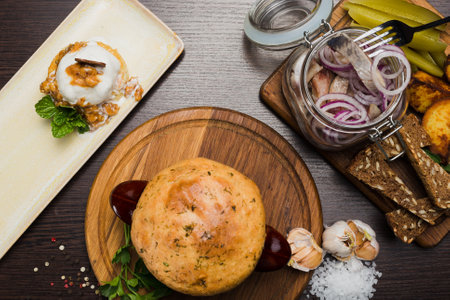 Set of Belarusian cuisine from a pot with herring meat with onions and dessertの写真素材