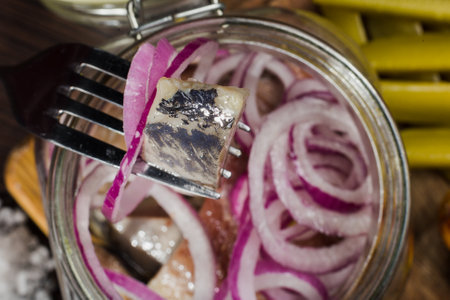Herring with onions in a glass jar with potatoes and pickled cucumberの写真素材