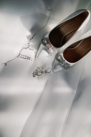 White wedding shoes with jewelry on white fabricの写真素材