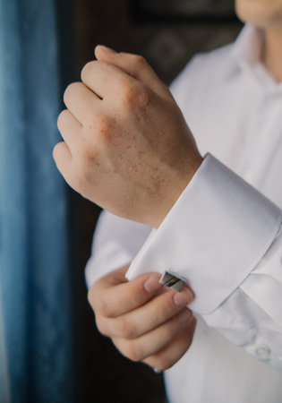 A man adjusts his shirt sleeve