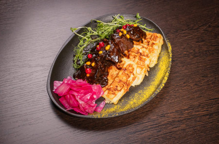 Fried meat with potato waffles and herbs on a plate