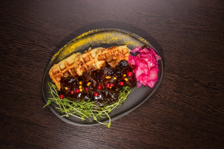 Fried meat with potato waffles and herbs on a plate