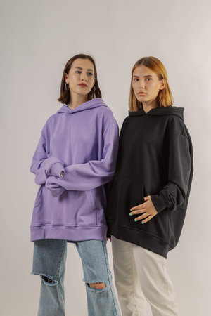 Two beautiful young girls in stylish clothes on a white background
