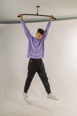 Handsome young guy in stylish clothes on white background in photo studio posing for camera