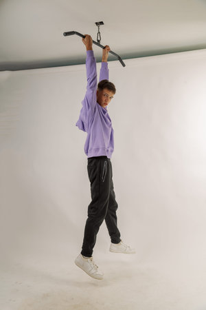 Handsome young guy in stylish clothes on white background in photo studio posing for camera