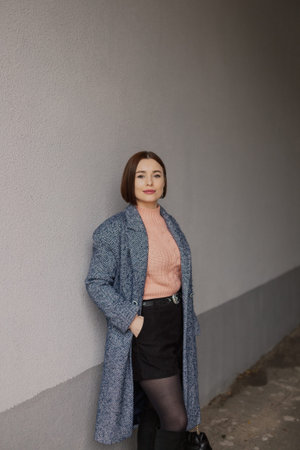 Beautiful young girl near a concrete wallの写真素材