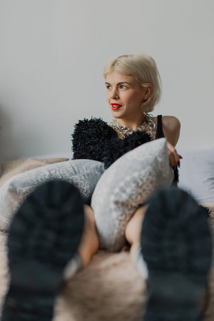 Beautiful woman posing for photographer on bed in photo studio