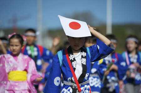 Zurich Switzerland - April 10, 2011: Japanese Boy with japan flag in hand walking the parade to the traditional spring festival Sechselauten.のeditorial素材